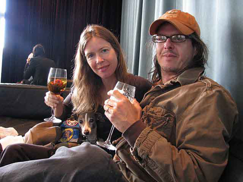 Man and woman relaxing with glasses of wine.