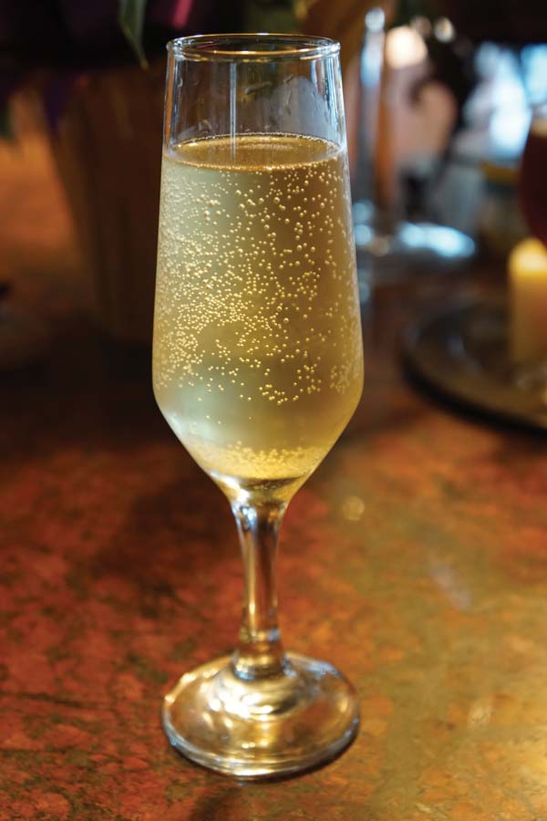 a stemmed fluted glass filled with sparkling wine