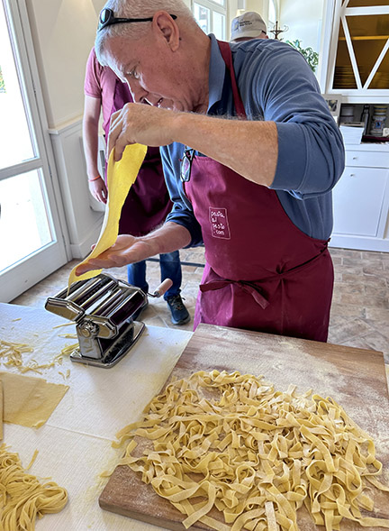 Man uses tabletop pasta maker to make pasta.